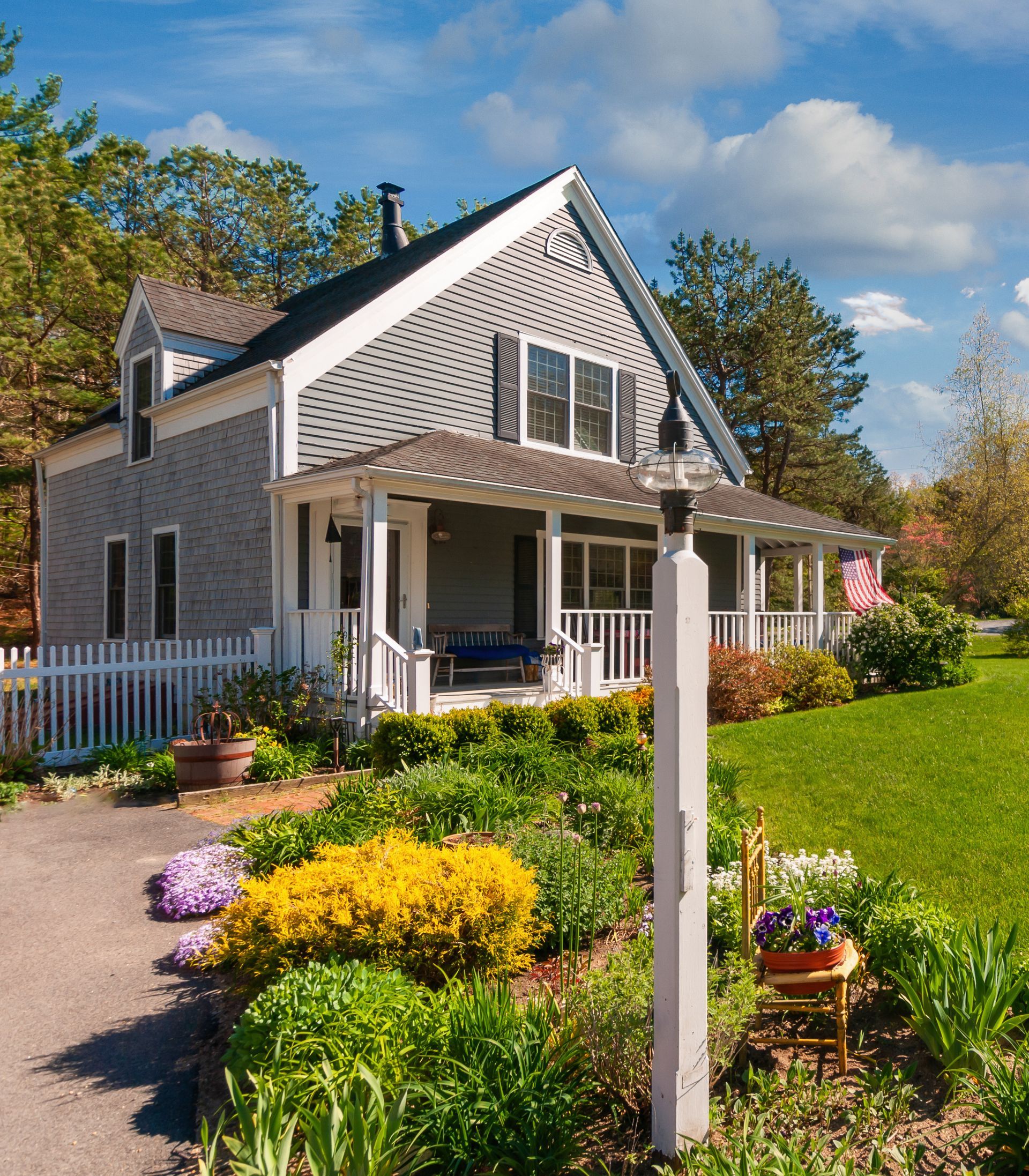 A house with a porch and a white picket fence
