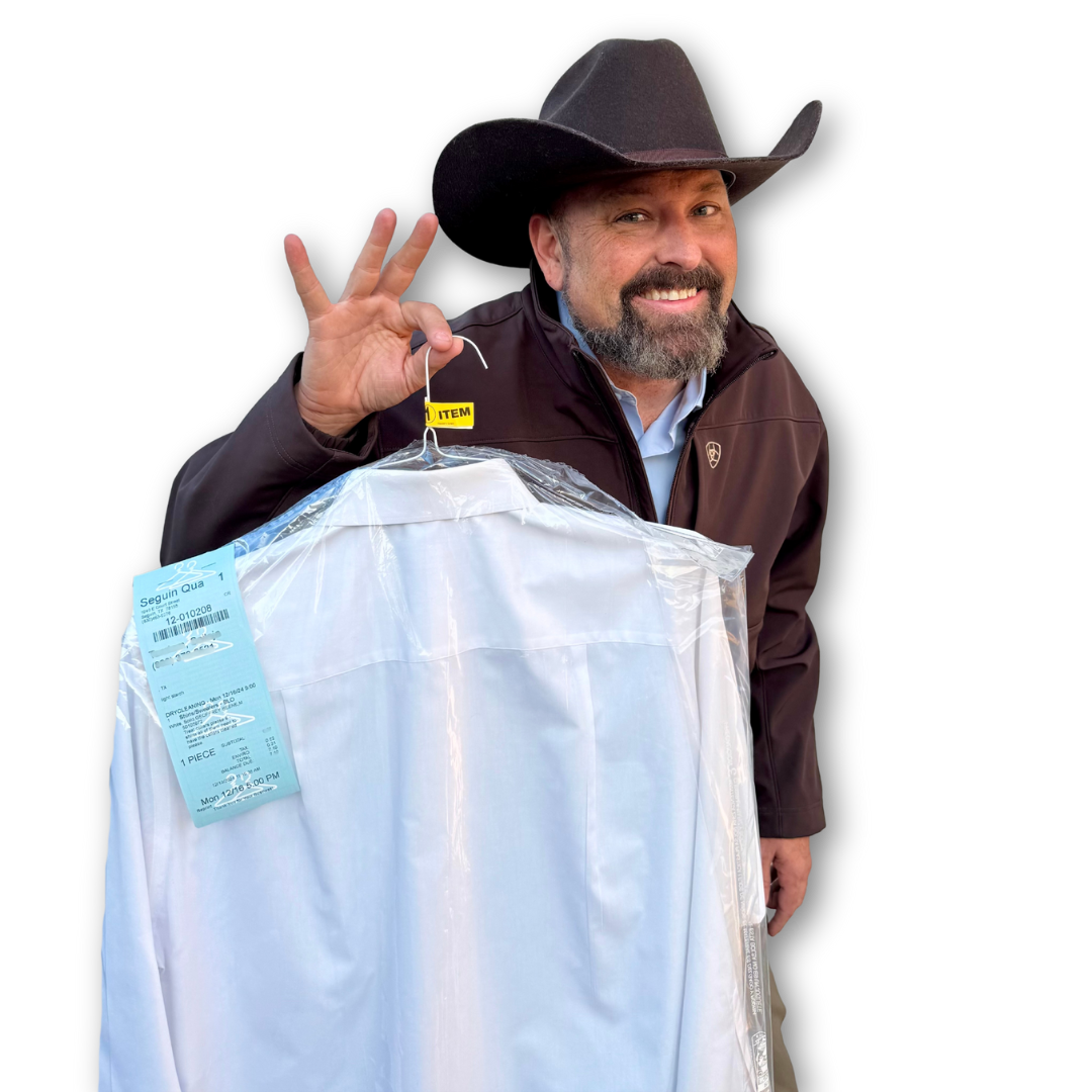 A man in a cowboy hat is holding a white shirt in a plastic bag