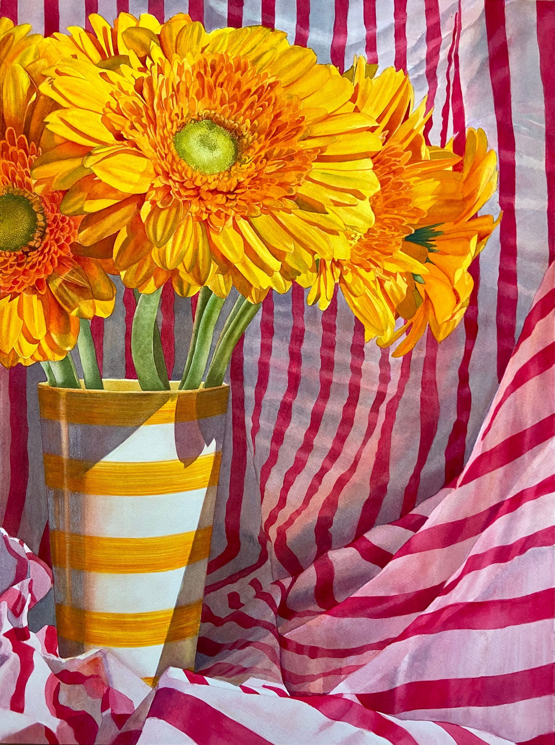 yellow gerbera flowers in a yellow striped vase with pink and white striped cloth behind