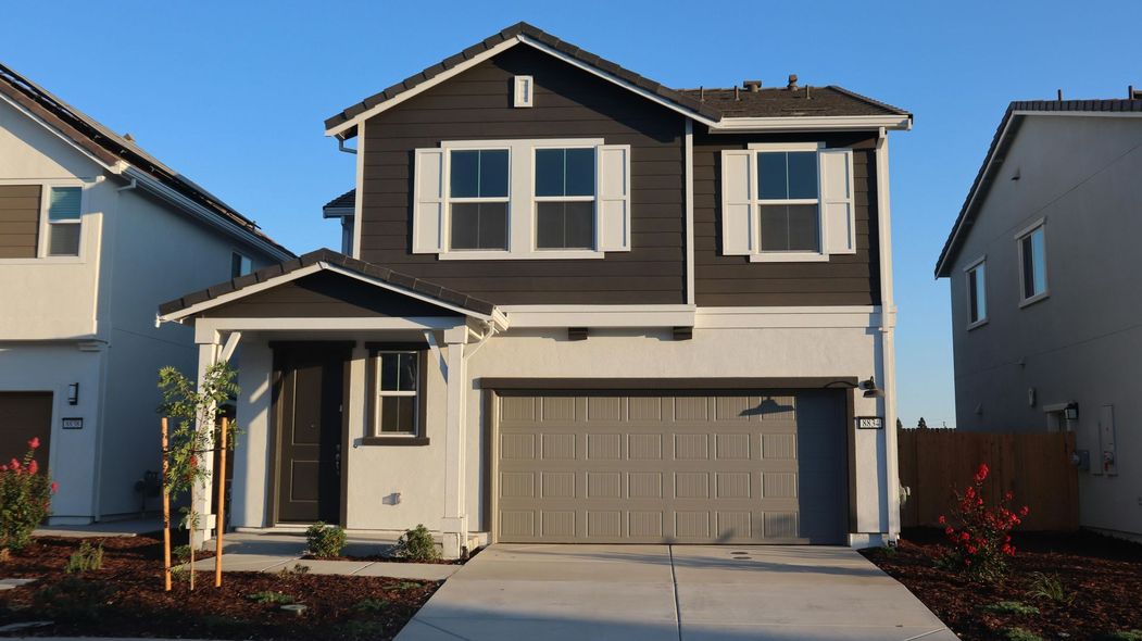 A large house with a garage and a driveway in front of it.