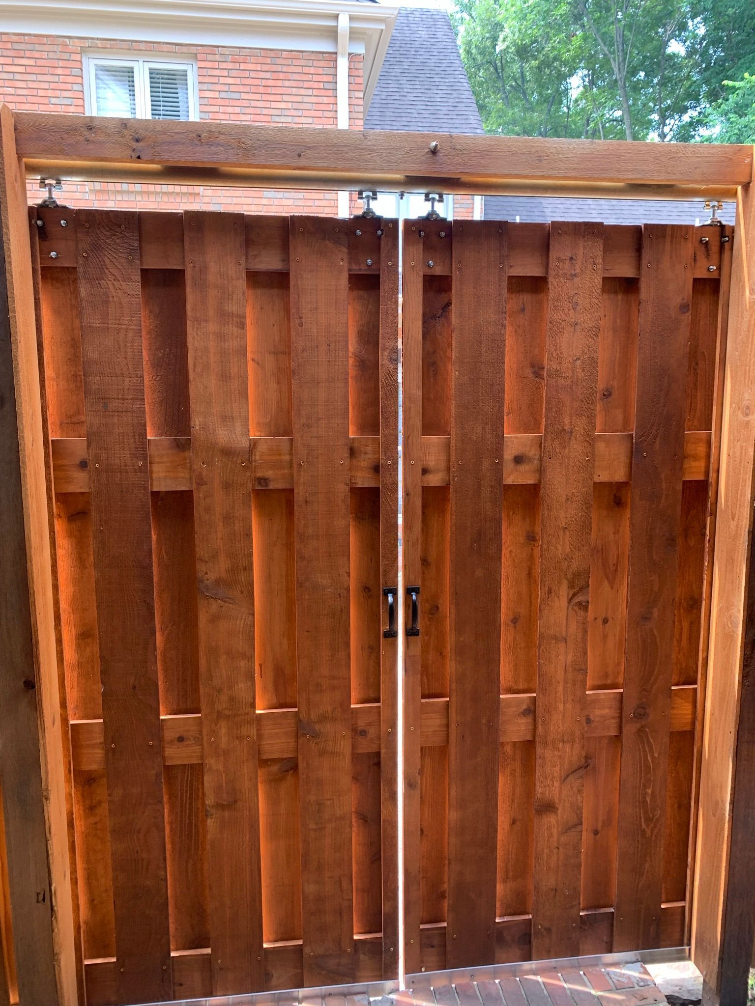 Wooden double gate in a fence. Brown wood, simple design, outdoor setting.