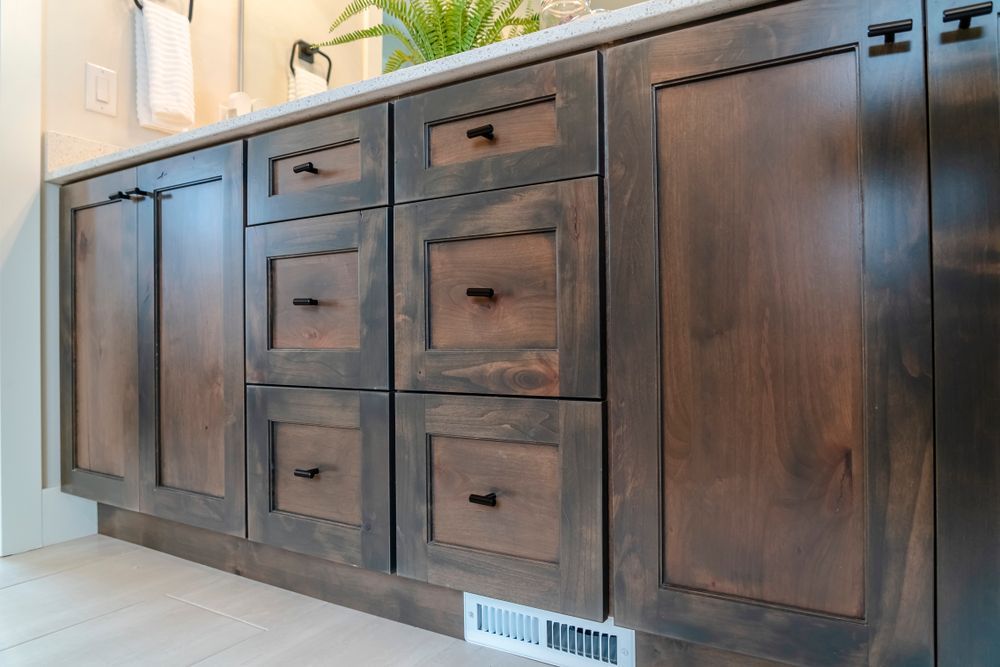 Dark brown wood bathroom vanity with drawers and cabinets; white floor.