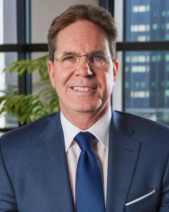 A man in a suit and tie is smiling for the camera