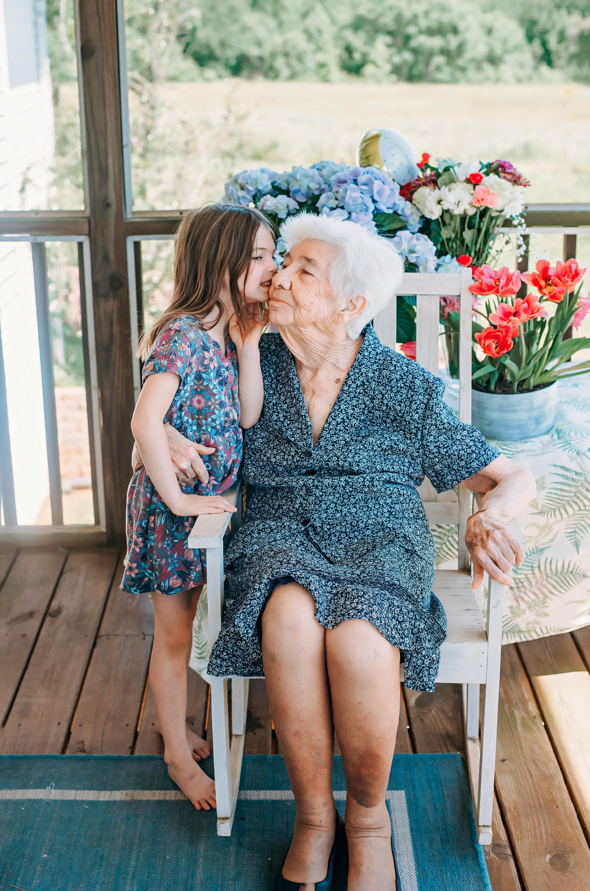 A young girl whispering in an elderly woman's ear