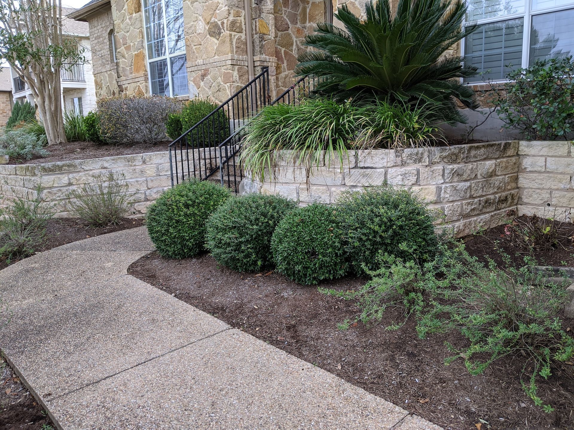 There is a walkway leading to the front of the house.