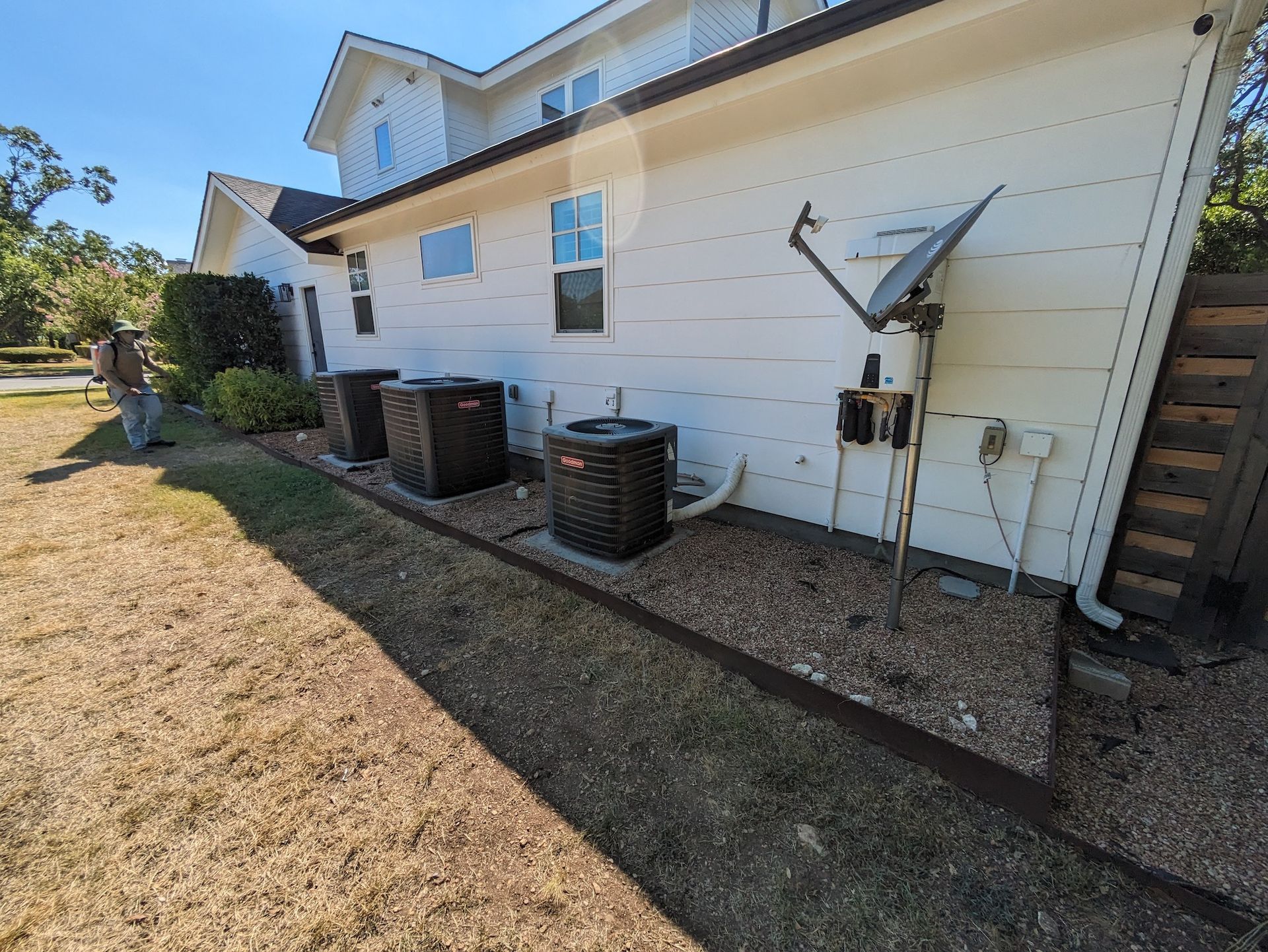 A white house with a lot of air conditioners on the side of it.