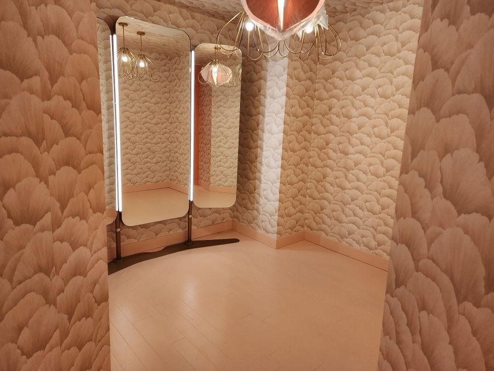 Pink dressing room with mirrors and textured walls.