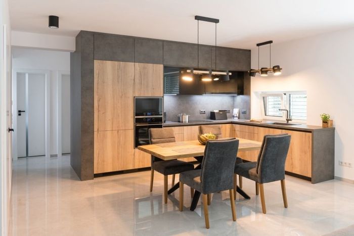 Dark kitchen with built in appliances in modern apartment