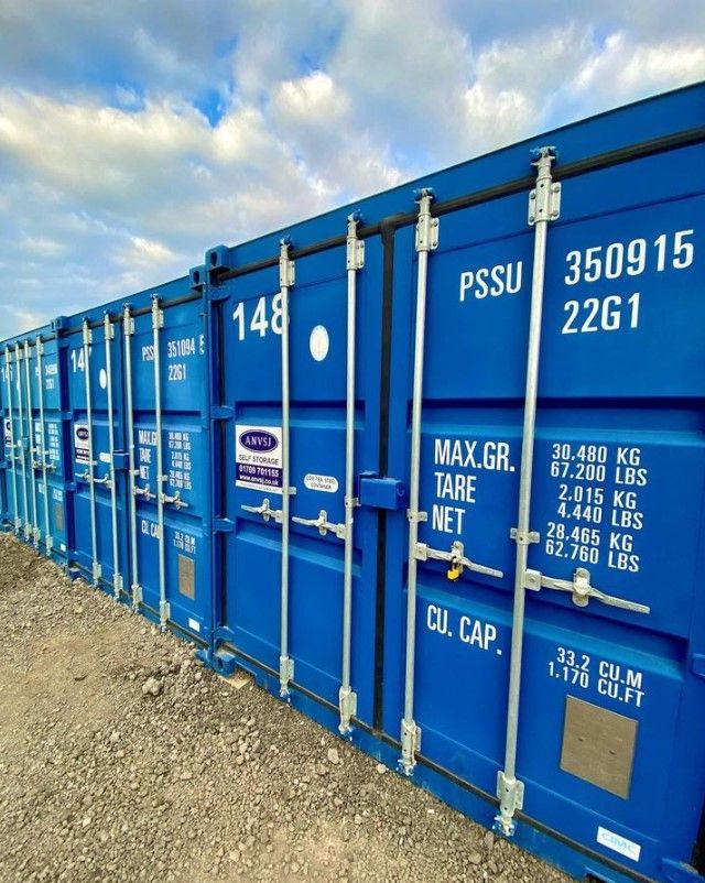 A row of blue shipping containers with ANVSJ on them