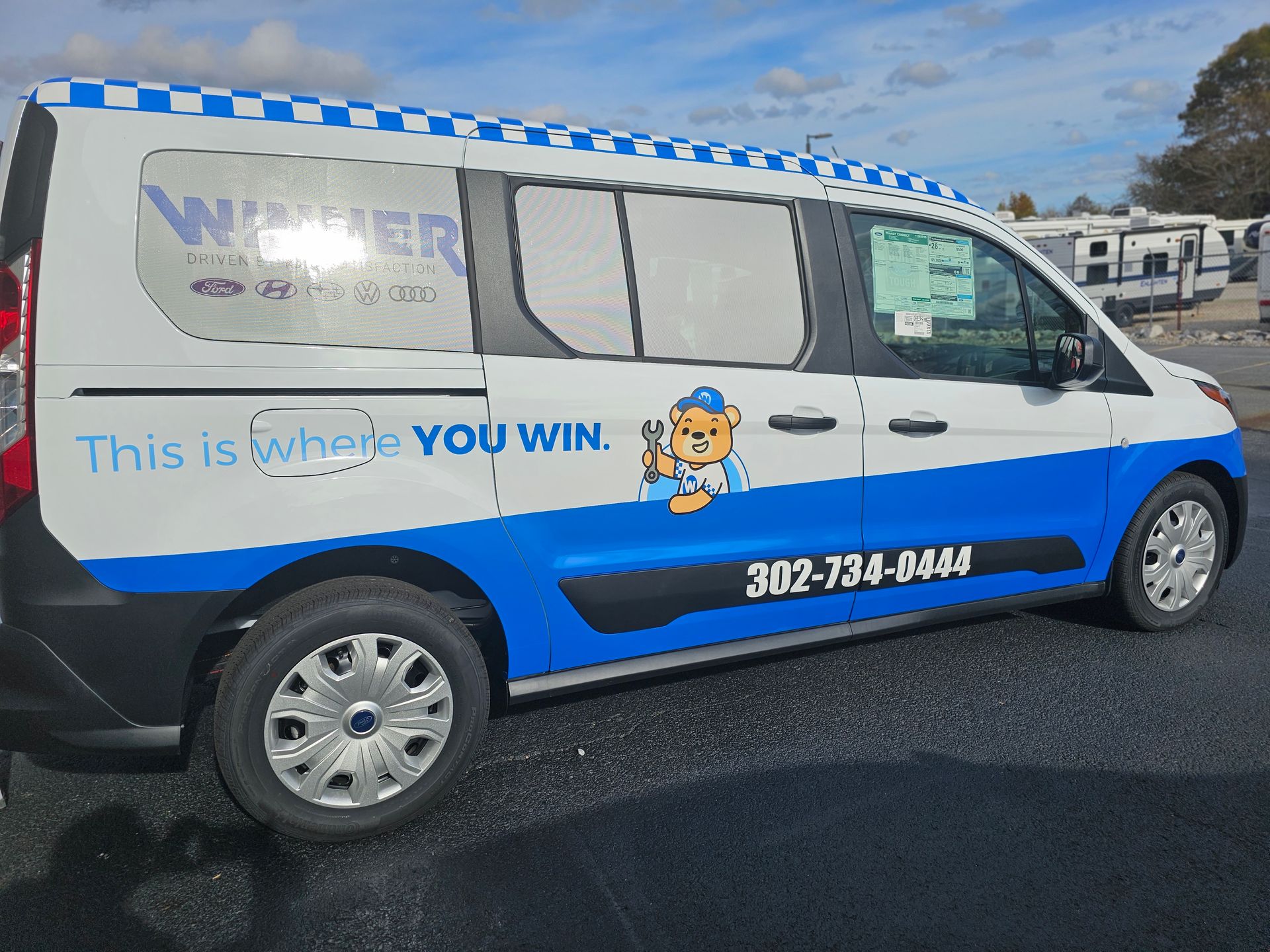 A blue and white van that says this is where you win