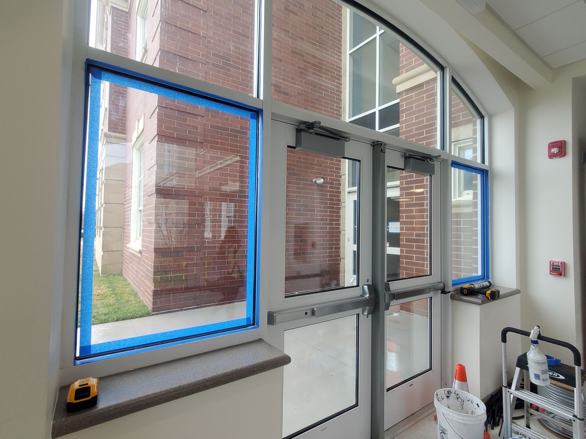 A building with a lot of windows is being painted blue.