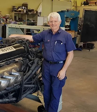 A Man is Welding a Pipe on a Ladder in a Room — Hardarc Engineering in Coolum Beach, QLD