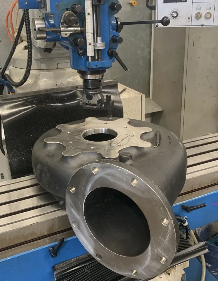 A Machine is Cutting a Piece of Metal With a Hole in It — Hardarc Engineering in Coolum Beach, QLD