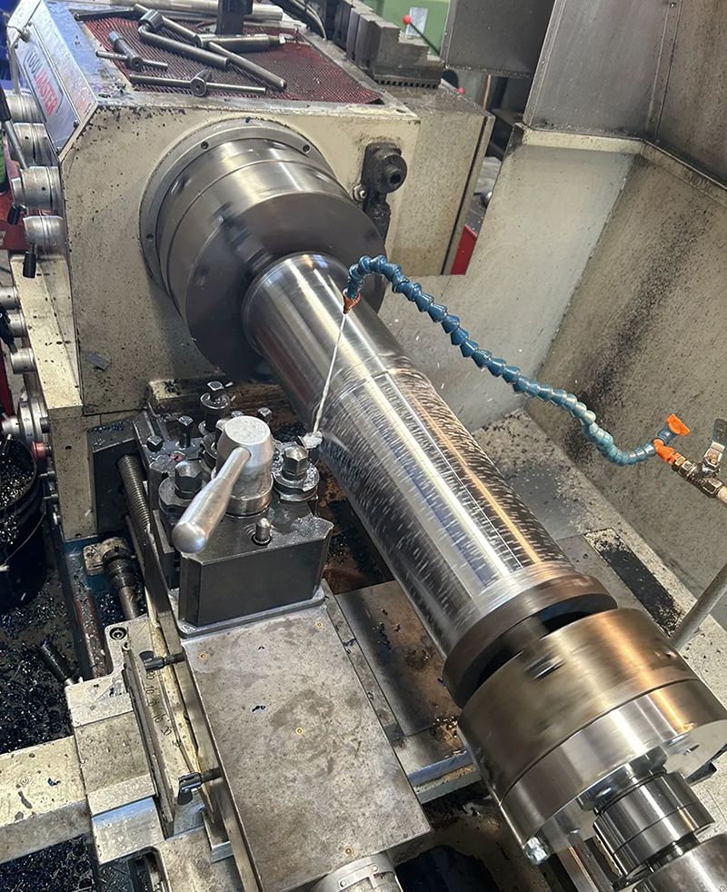 A Large Metal Pipe is Being Cut on a Machine — Hardarc Engineering in Bundaberg, QLD