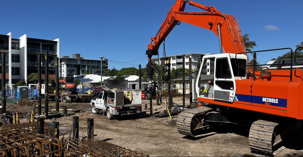 A Large Orange Excavator is Working on a Construction Site — Hardarc Engineering in Harvey Bay, QLD