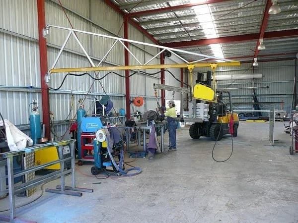 A Man is Working in a Factory With a Forklift in the Background — Hardarc Engineering in Coolum Beach, QLD