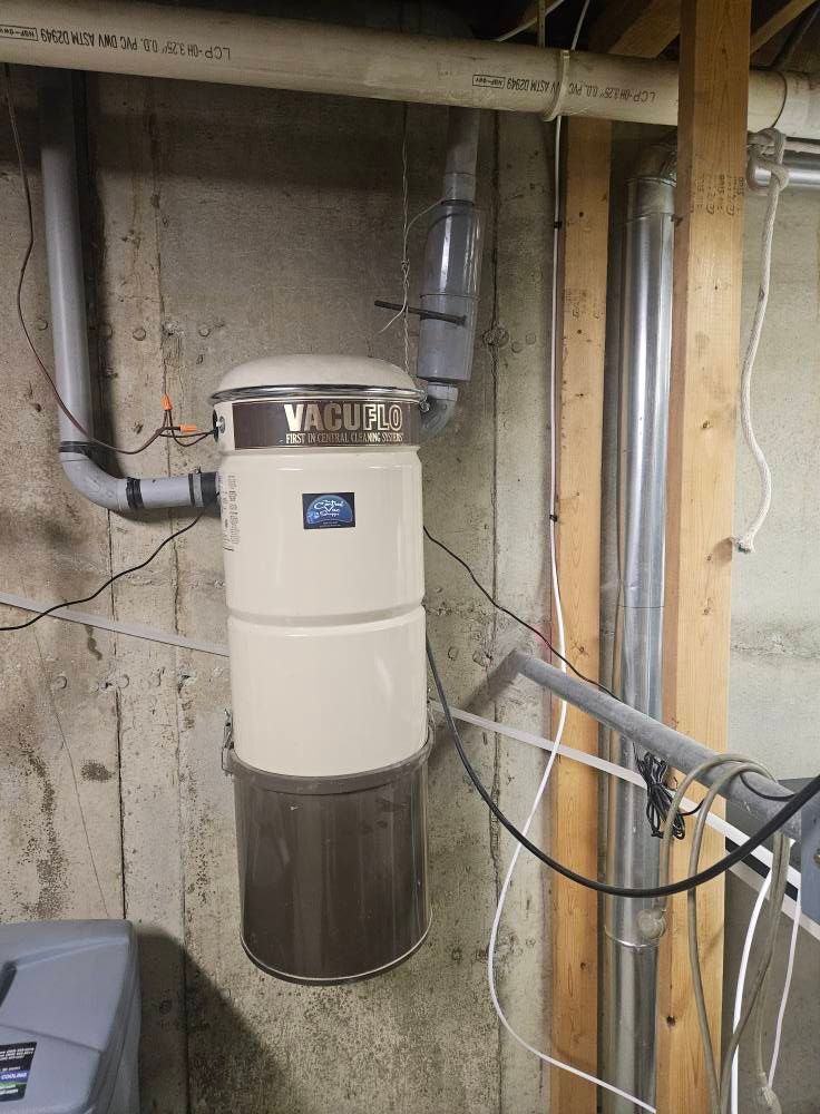 A vacuum cleaner is hanging on a wall in a basement.