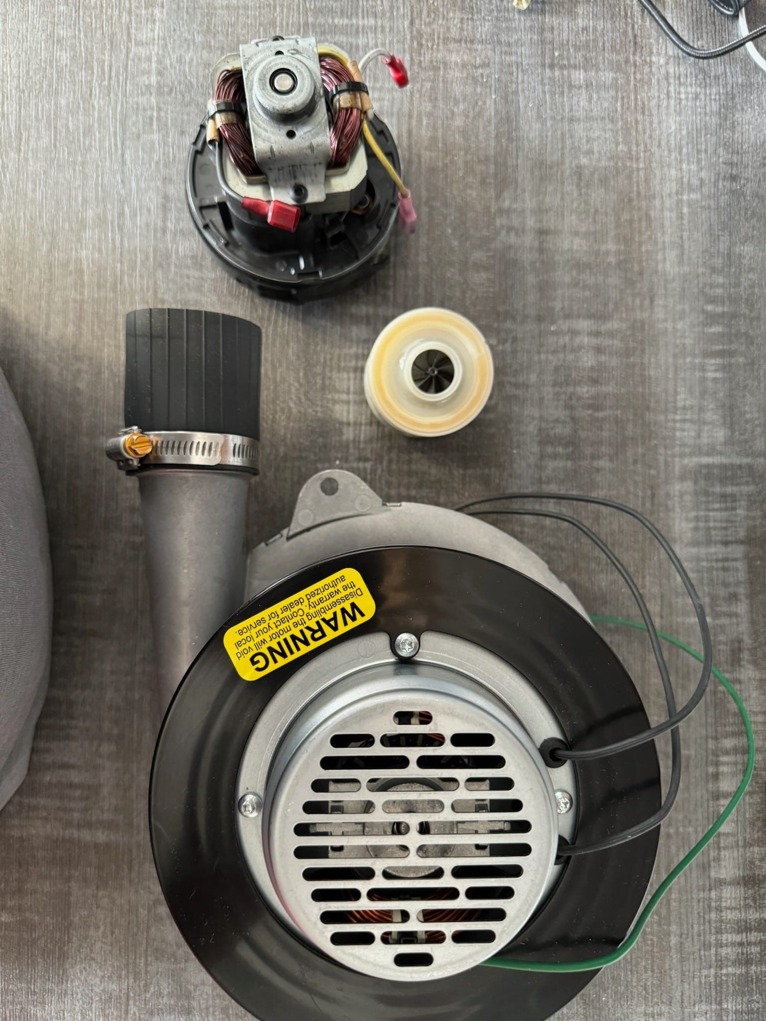A blower with a warning label on it is sitting on top of a wooden table.