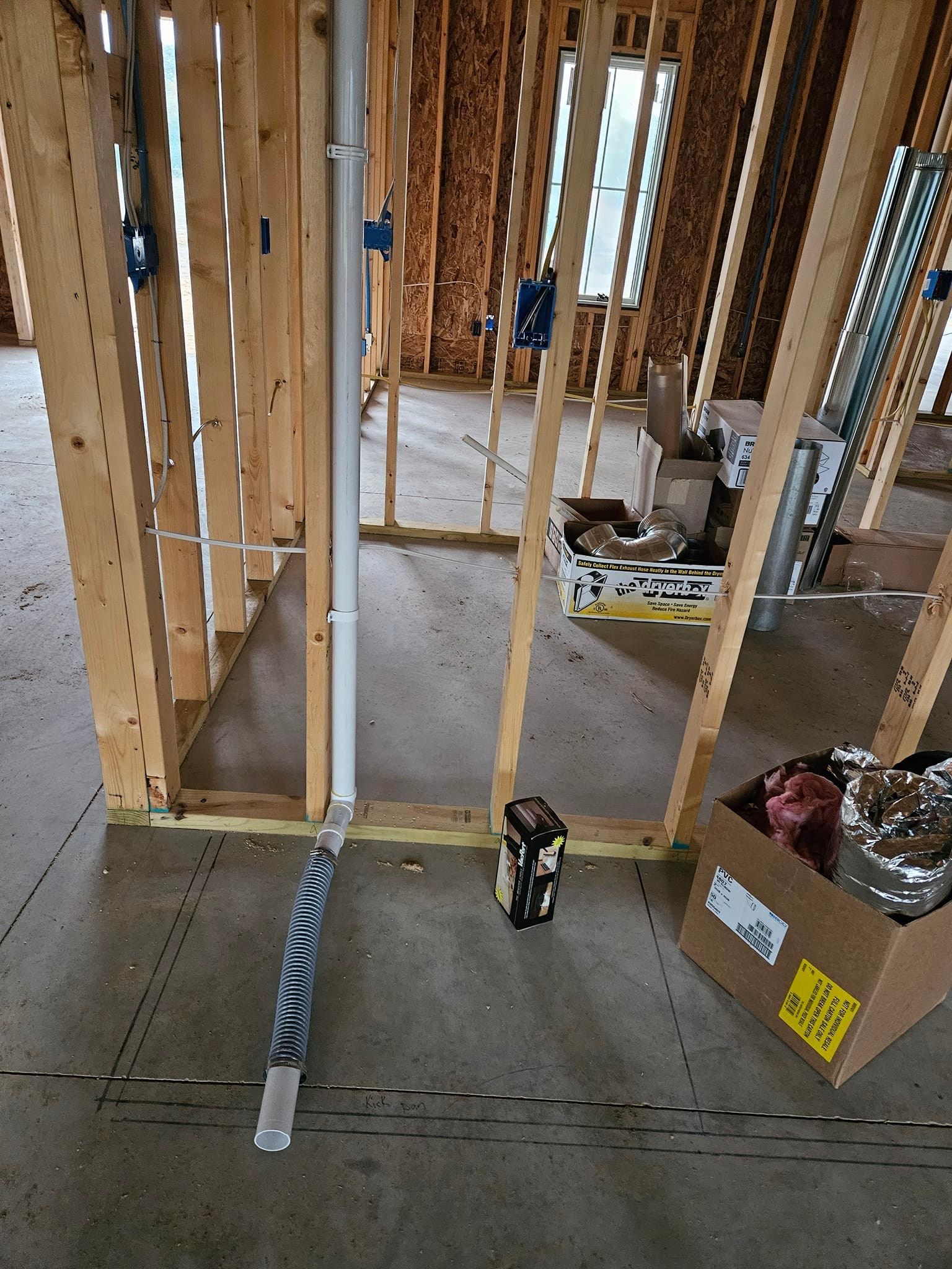 A room in a house under construction with a box on the floor.