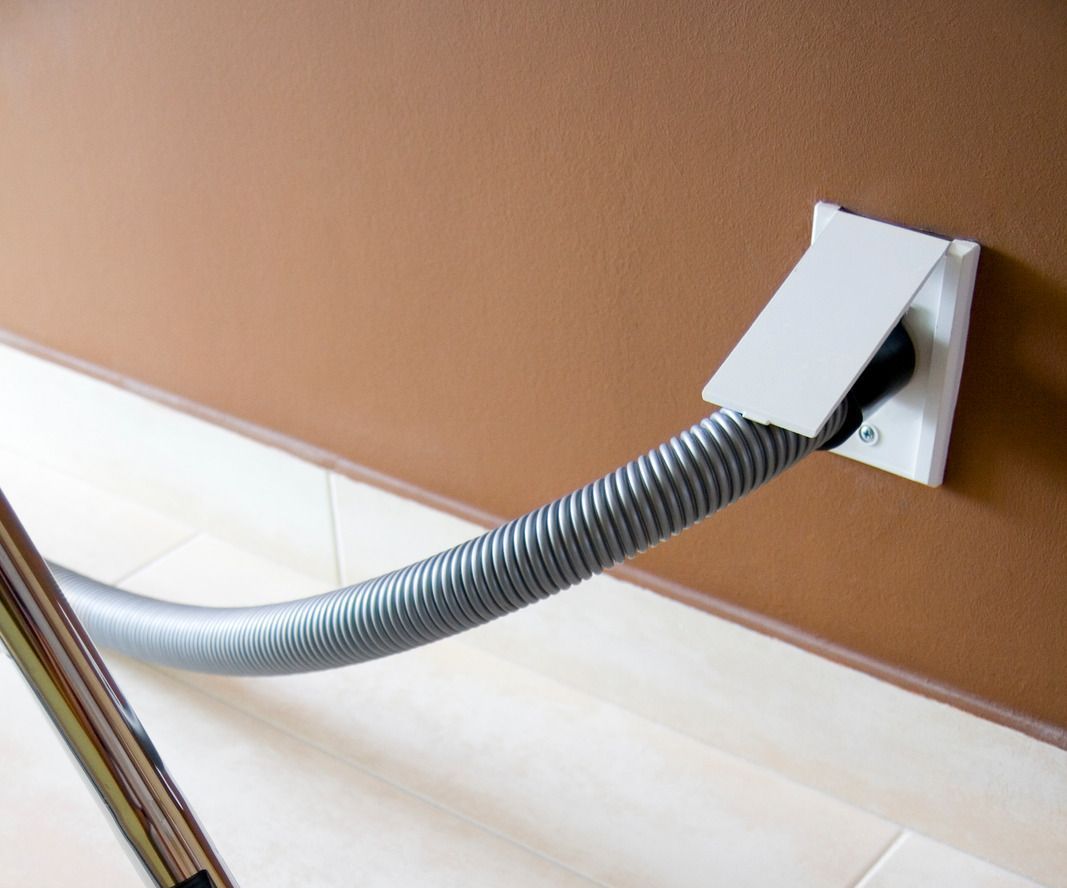 A vacuum hose is attached to a wall outlet