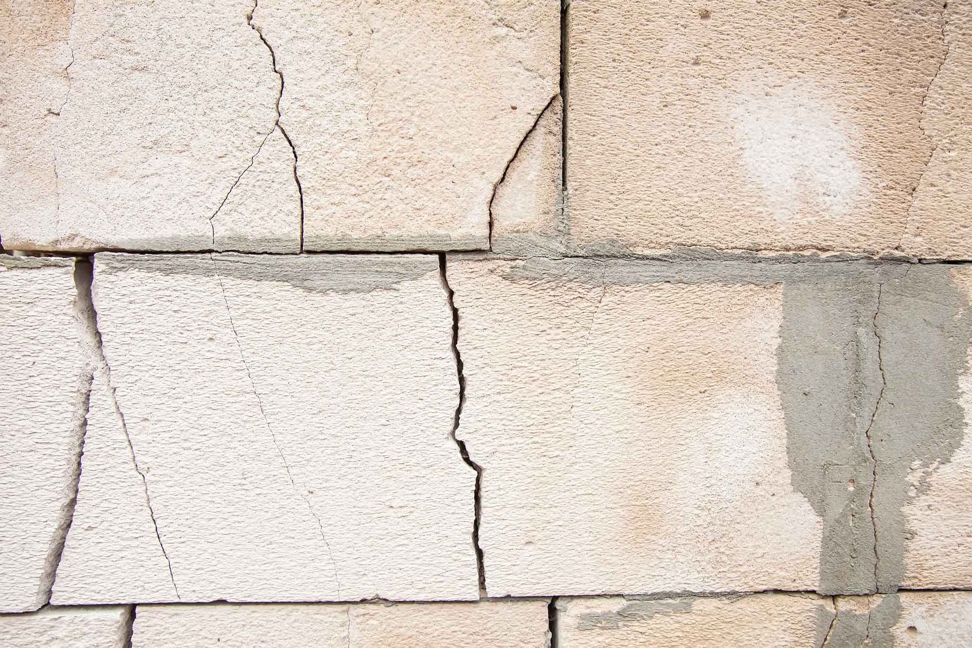 Cracked concrete blocks on a basement wall showing visible damage that needs repair.