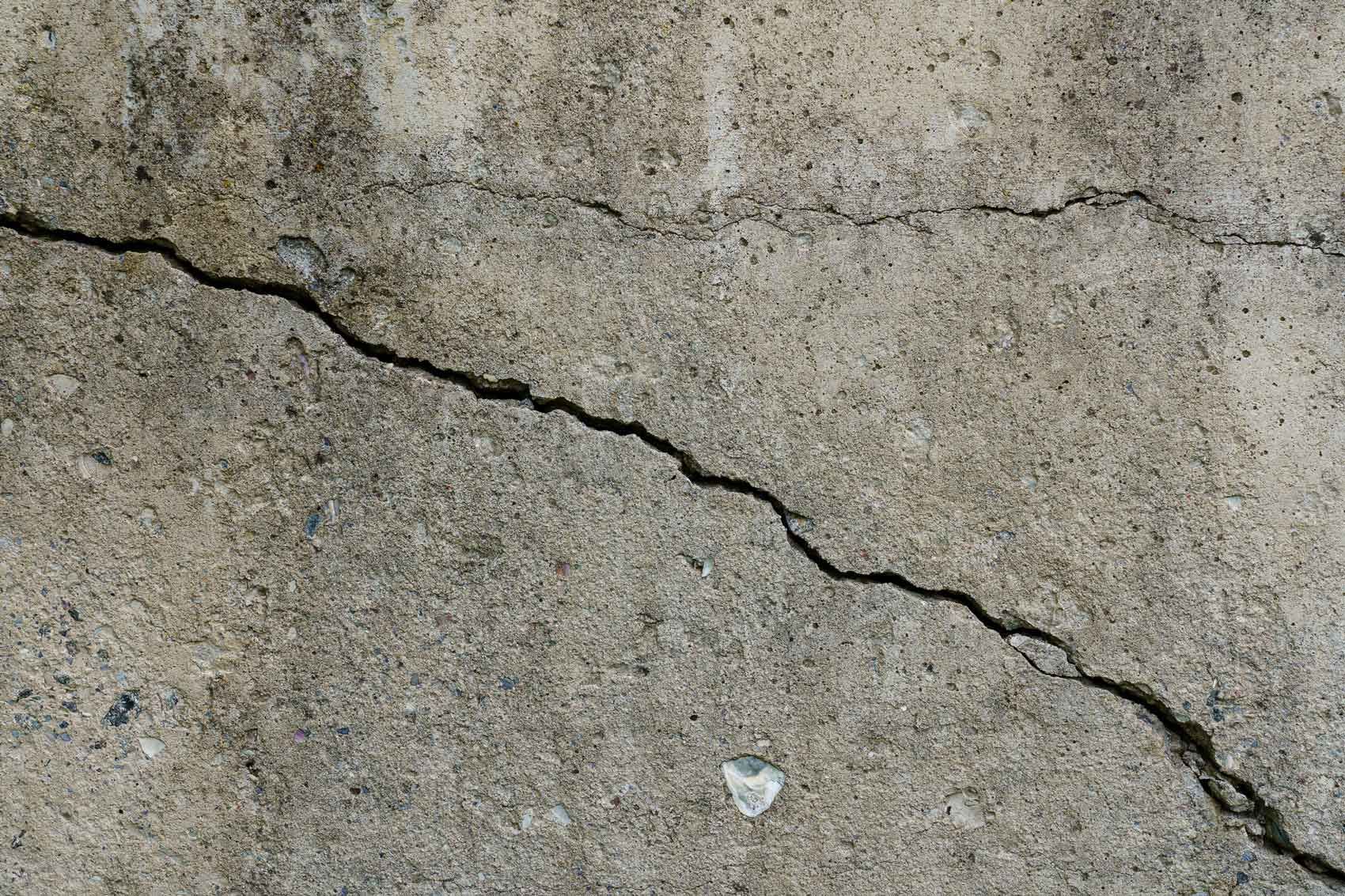 Long crack running across a concrete wall, showing damage that needs repair.