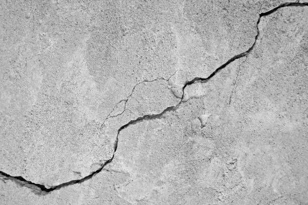 Diagonal crack in gray concrete, representing the need of basement wall crack repair services.