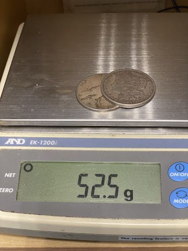Two coins are sitting on top of a digital scale.