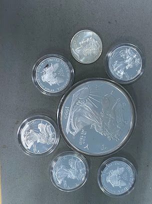 A group of silver coins are sitting on top of each other on a table.