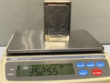 A silver bar is sitting on top of a digital scale.