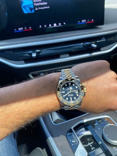 A man is wearing a watch on his wrist in a car.