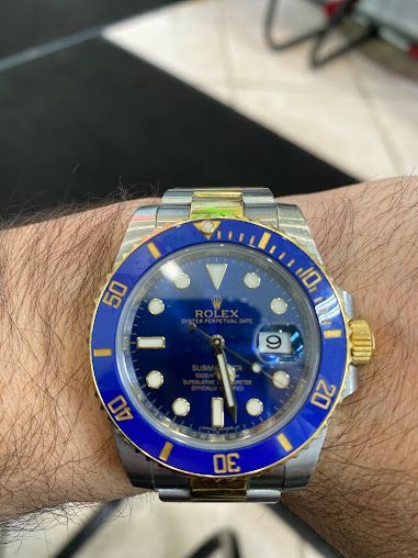 A man is wearing a rolex watch on his wrist.