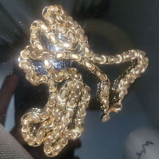 A close up of a gold chain on a table