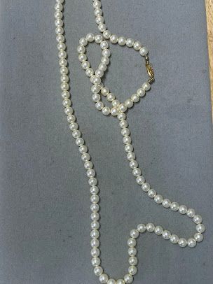 A pearl necklace and bracelet are on a table
