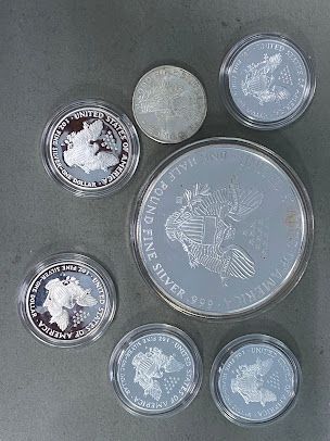 A group of silver coins are sitting on top of each other on a table.
