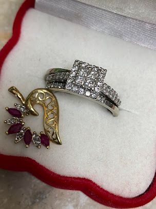 A ring and a brooch are in a box.