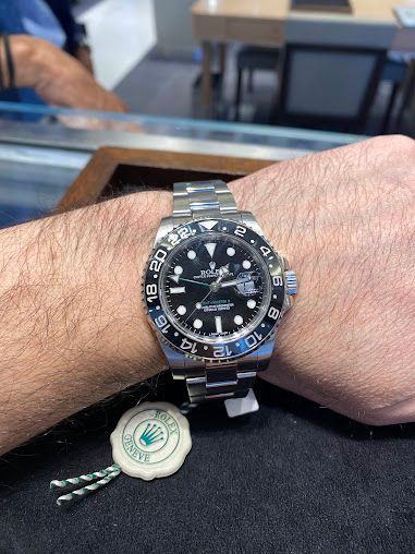 A man is wearing a rolex watch on his wrist.