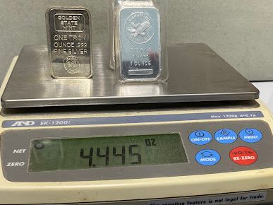 Two bars of silver are sitting on top of a digital scale.