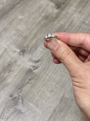 A person is holding a diamond ring in their hand.