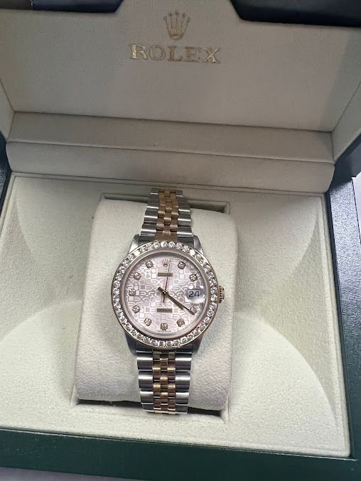 A rolex watch is sitting in a box.