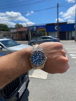 A man is wearing a rolex watch on his wrist.