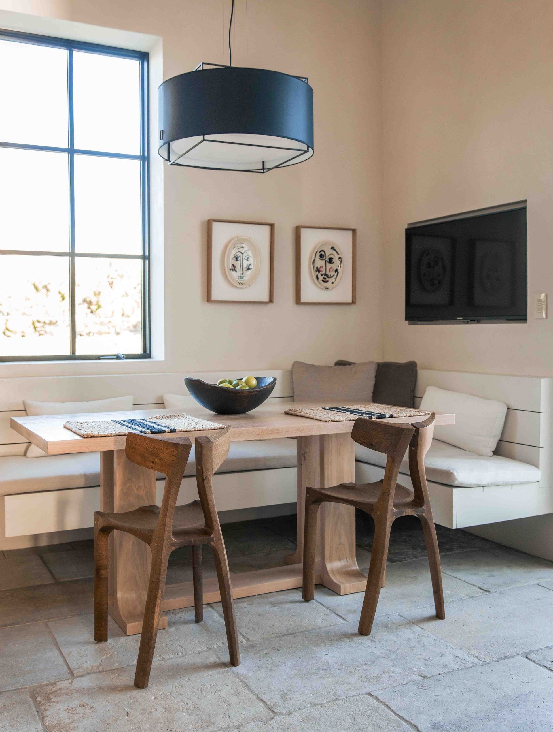 A dining room with a table and chairs and a couch.