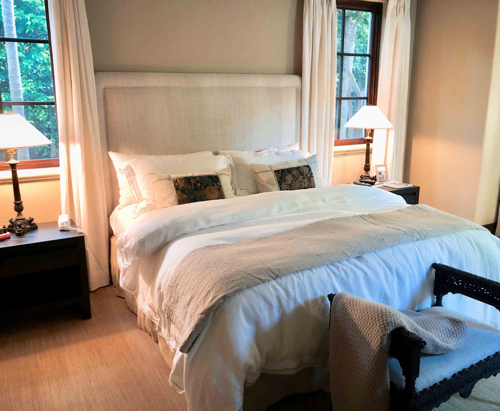 A bedroom with a large bed and two lamps