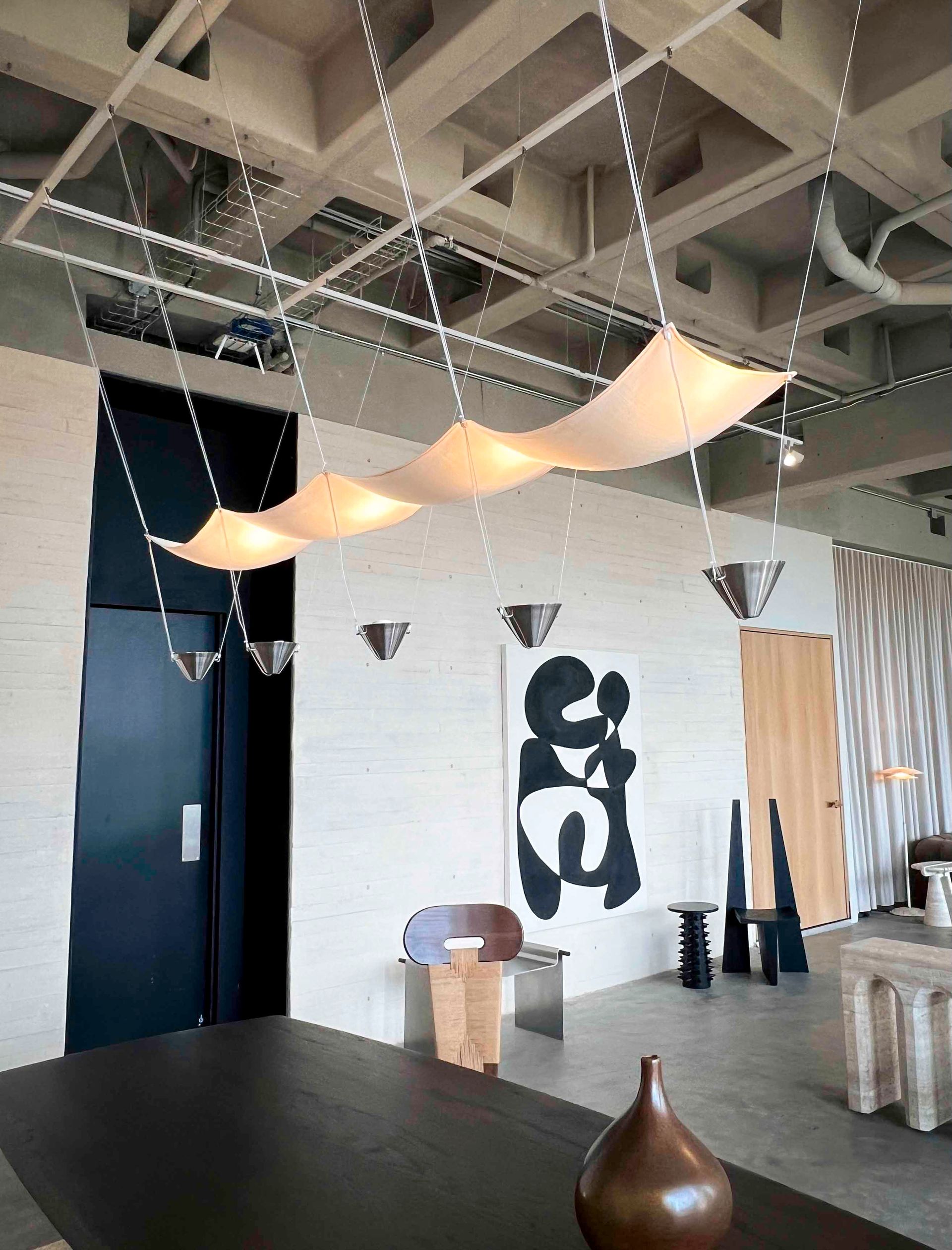 A marble table with a lamp on it in a room with arched windows.