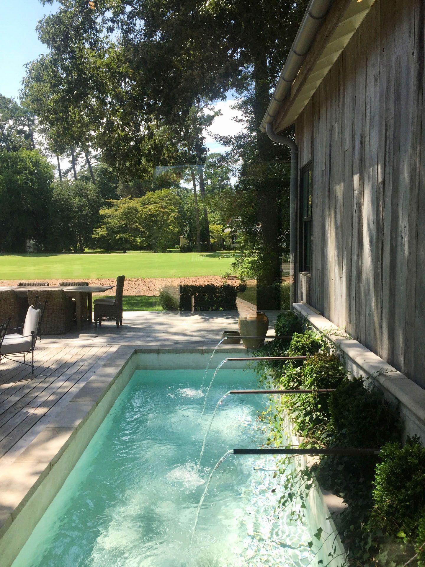 A swimming pool with a fountain in the middle of it