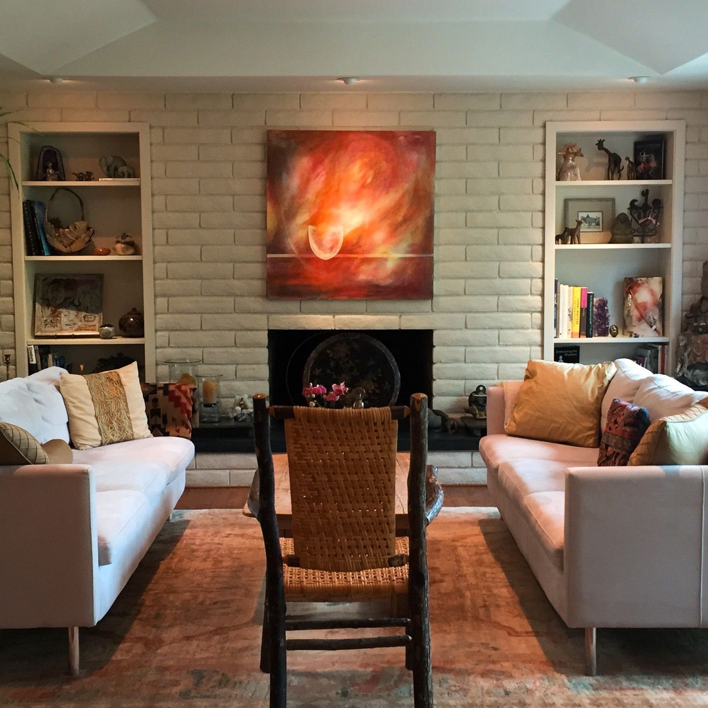 A living room with two couches a chair and a fireplace