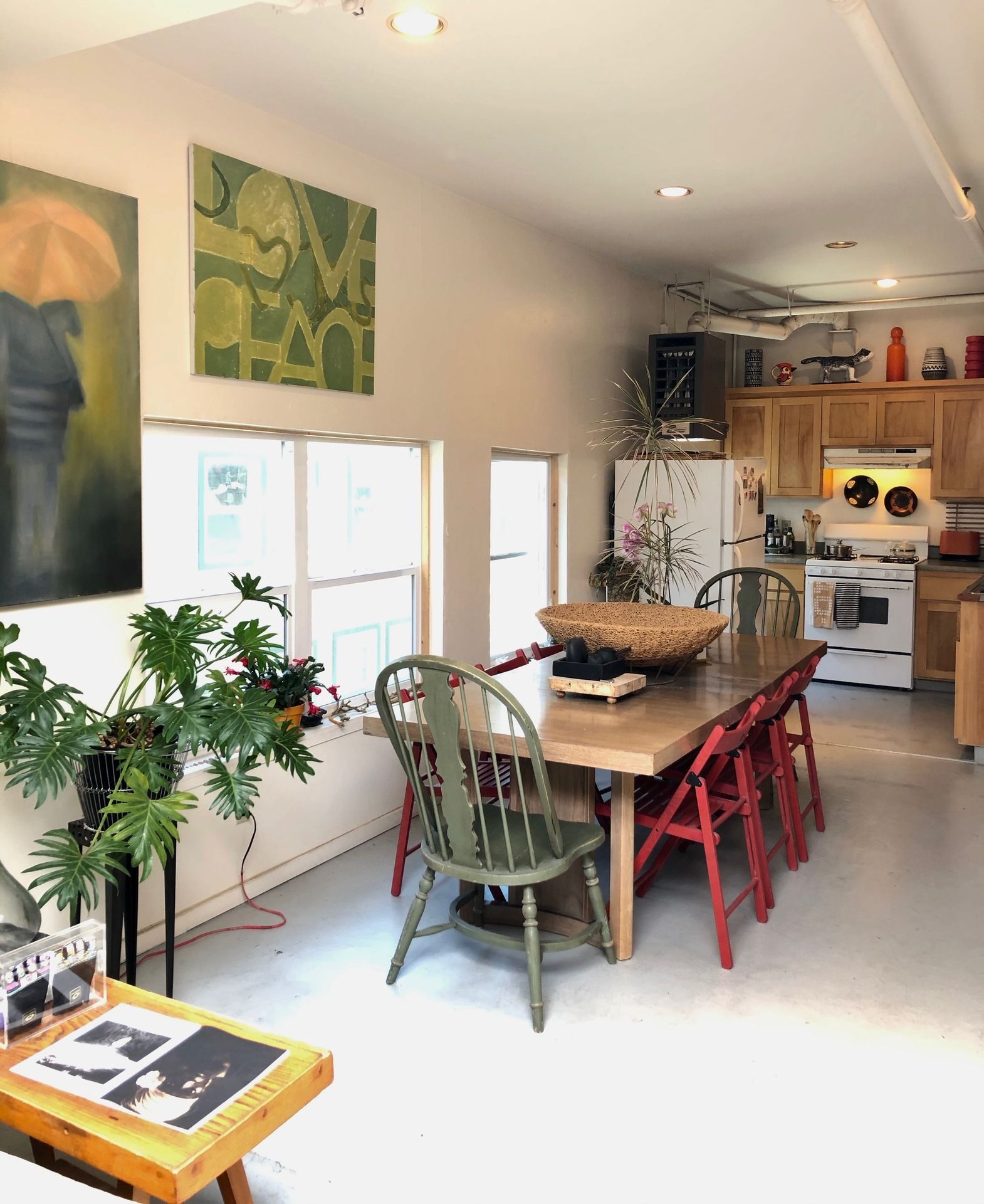 A living room with a table and chairs and a painting on the wall