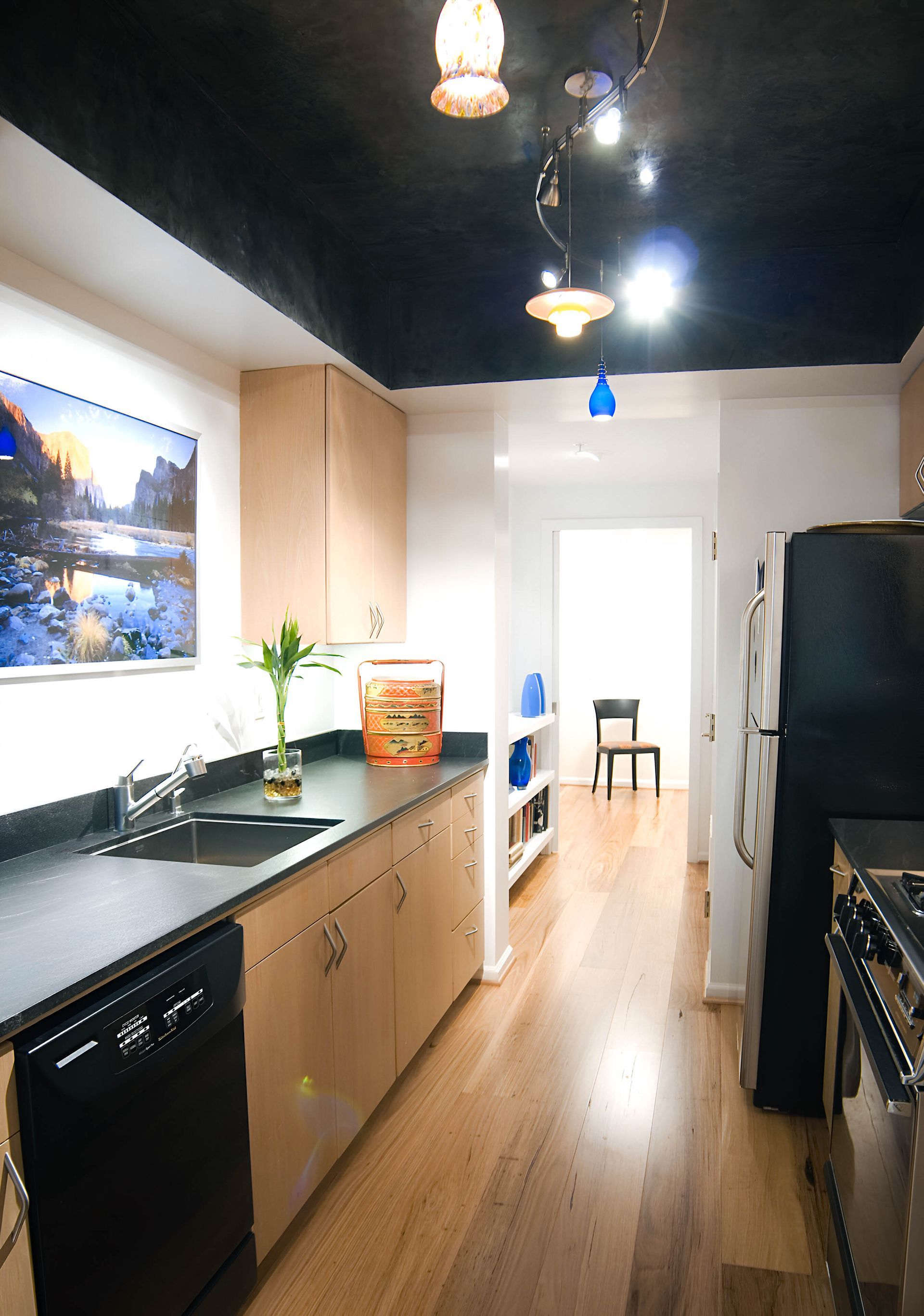 A kitchen with a picture on the wall above the sink