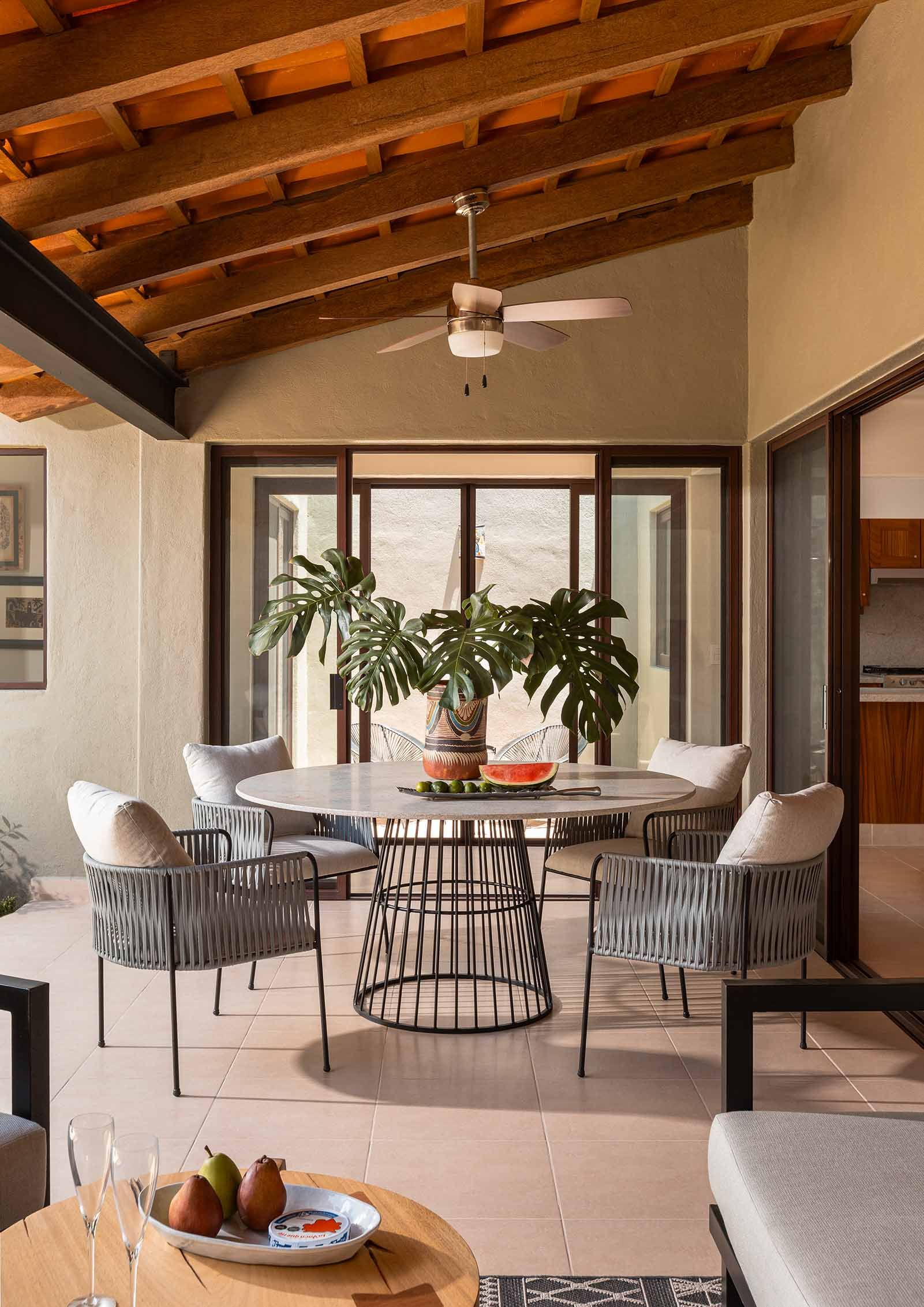 A living room with a table and chairs and a ceiling fan.