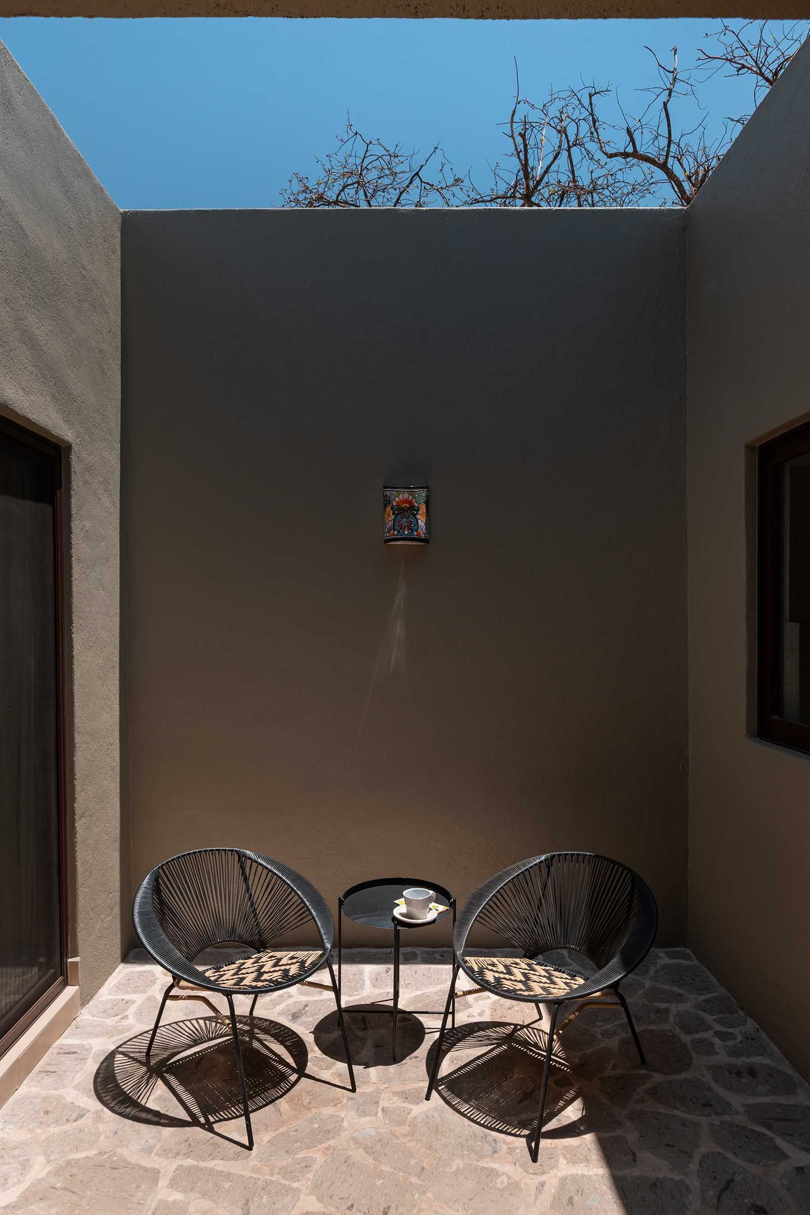 There are two chairs and a table on the patio.